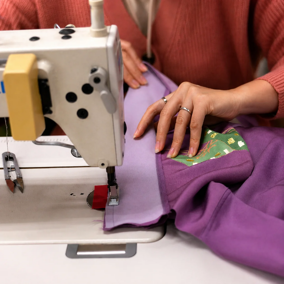 Sewing each shirt while aligning the kimono artwork.